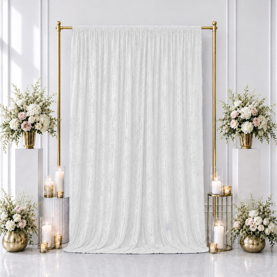 Elegant white wedding backdrop with gold frame, candles, and floral arrangements