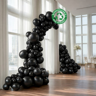 Black biodegradable balloons archway decor for events. Eco-friendly design.