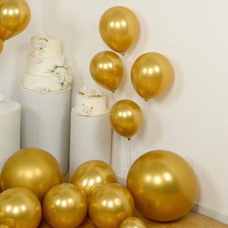 Gold balloons in various sizes, arranged with cake and floral decor.