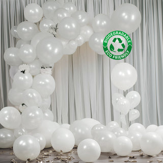 White biodegradable balloons arranged in an arch with scattered balloons below. #whtbkgd