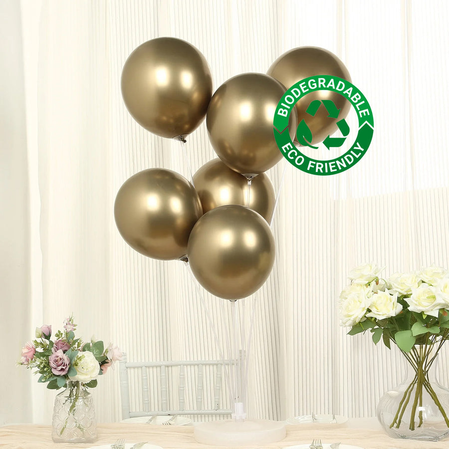 Gold biodegradable balloons in a clear display against a neutral backdrop.