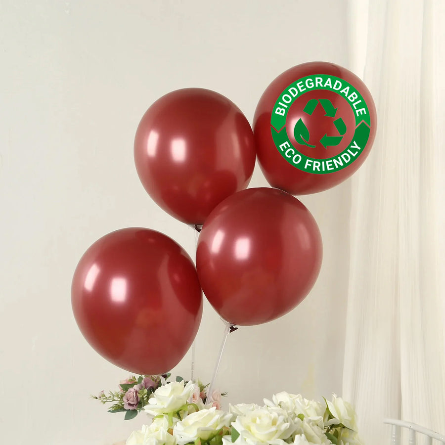 Red biodegradable balloons with eco-friendly label against a neutral background.