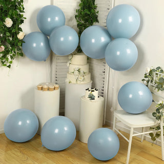 Blue balloons arranged around white pedestals with floral accents.