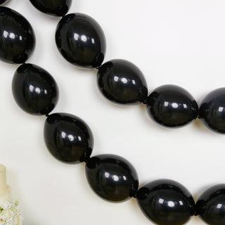 Black oval balloons strung together for party decoration