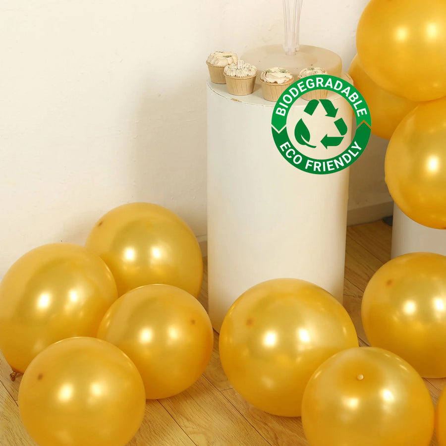 Gold biodegradable balloons on a wooden floor with eco-friendly label.