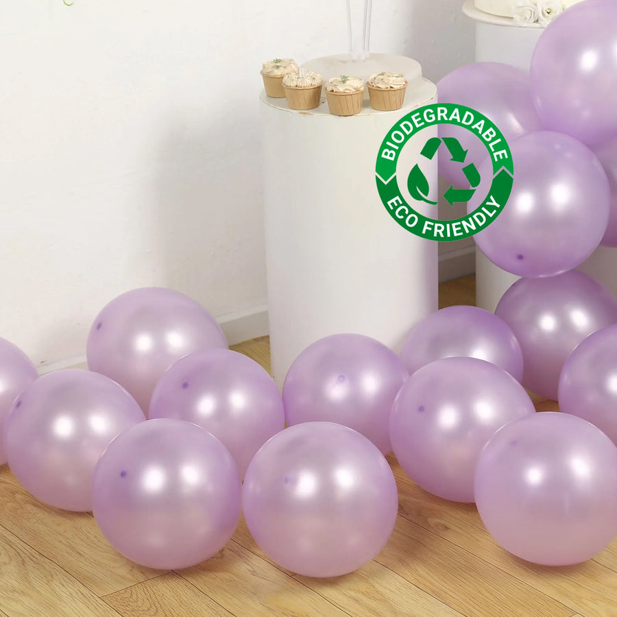 Biodegradable purple balloons scattered on a wooden floor with cupcakes.