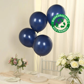 Biodegradable navy blue balloons on a table with flowers in vases.