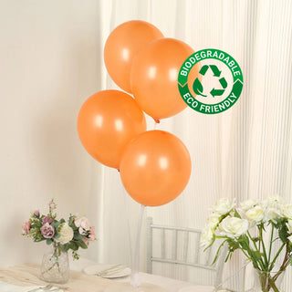 Set of four biodegradable orange balloons with eco-friendly label.