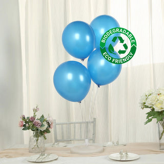 Four blue biodegradable balloons on a table with flowers. Eco-friendly design.