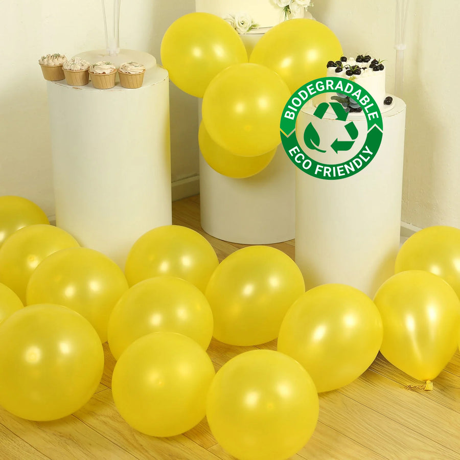 Yellow biodegradable balloons scattered on a wooden floor.