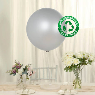 Silver biodegradable balloon with eco-friendly label on a table with flowers.