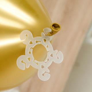 Gold balloon with a clear decorative tie attachment.