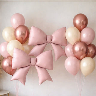 Pink and rose gold balloons with large bows for celebrations or events.