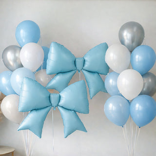 Blue and silver balloons with large decorative bows on a plain backdrop.