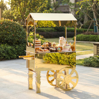 Gold dessert cart showcasing an array of cupcakes and pastries in an outdoor setting.