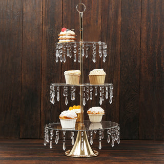 Gold three-tiered cupcake stand with crystal accents and decorated pastries.