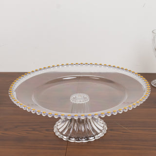 Clear glass cake stand with decorative gold accents.