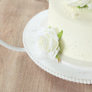 White floral cake with elegant decoration on a white cake stand.