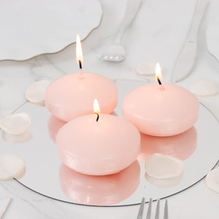 Pink round candles on a mirrored surface with rose petals.