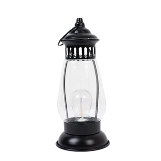 Black vintage lantern with clear glass and decorative top.