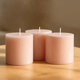 Pink cylindrical candles grouped on a wooden table.