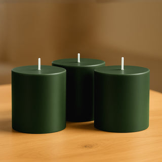 Green cylindrical candles on a wooden table.
