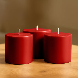 Red pillar candles on a wooden table.