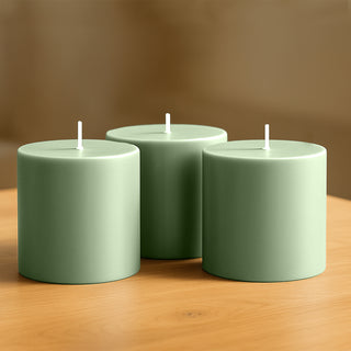 Green cylindrical candles on a wooden table.