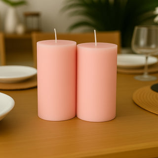 Pink pillar candles on a wooden table with a modern setup.