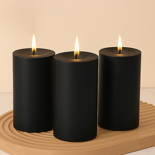 Black pillar candles with flames on a decorative wooden tray.