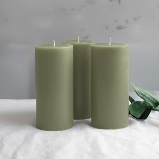Three green pillar candles with a minimalist style.