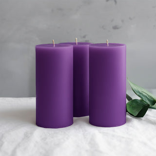 Purple pillar candles displayed with greenery