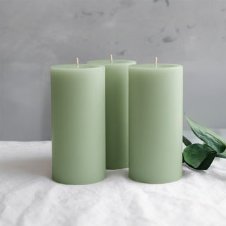 Green pillar candles arranged with greenery accents.