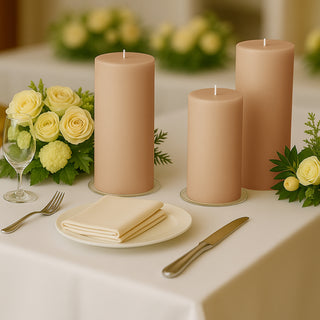Three elegant beige candles on a dining table with flowers and tableware.