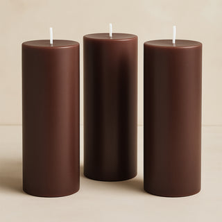 Brown pillar candles in varying heights, elegantly displayed.