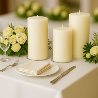 Elegant white candles with floral arrangements on a dining table.