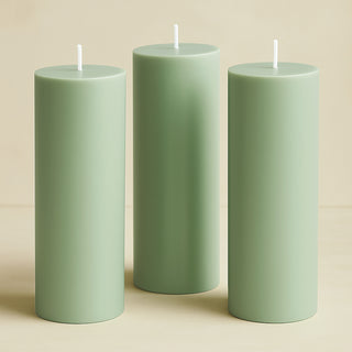 Three green cylindrical candles on a beige background.