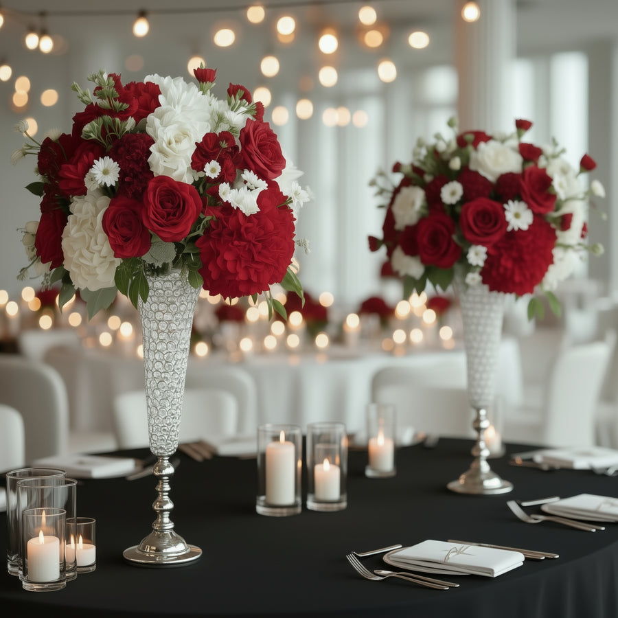 Elegant red and white floral arrangements in crystal vases for event decor.