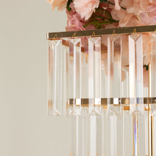 Elegant crystal chandelier with hanging prisms and floral arrangement.