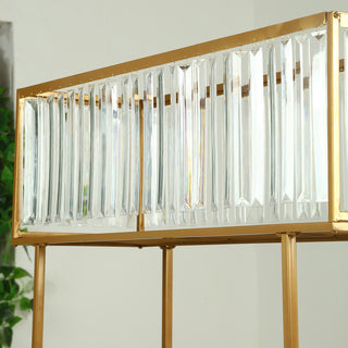 Gold and crystal pendant light fixture with geometric design.