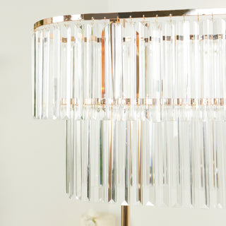 Elegant crystal chandelier with gold accents and hanging prisms.