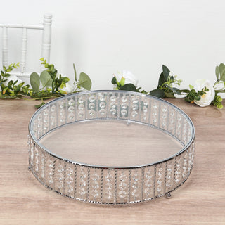 Round crystal cake stand with silver base, perfect for elegant displays.