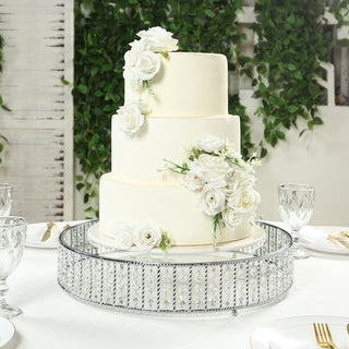 Elegant three-tier wedding cake adorned with white roses on a decorative stand.