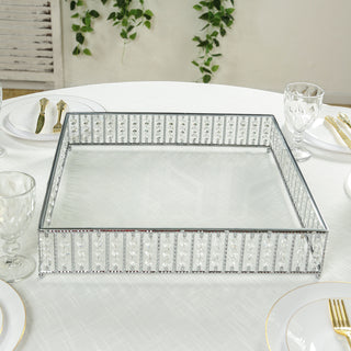 Elegant mirrored serving tray with crystal accents on a dining table.
