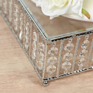 Decorative mirrored box with crystal accents and floral arrangement.