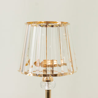 Elegant clear glass lamp with gold accents and a pleated shade