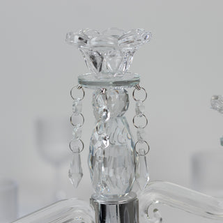 Crystal chandelier detail with elegant floral design and hanging accents.