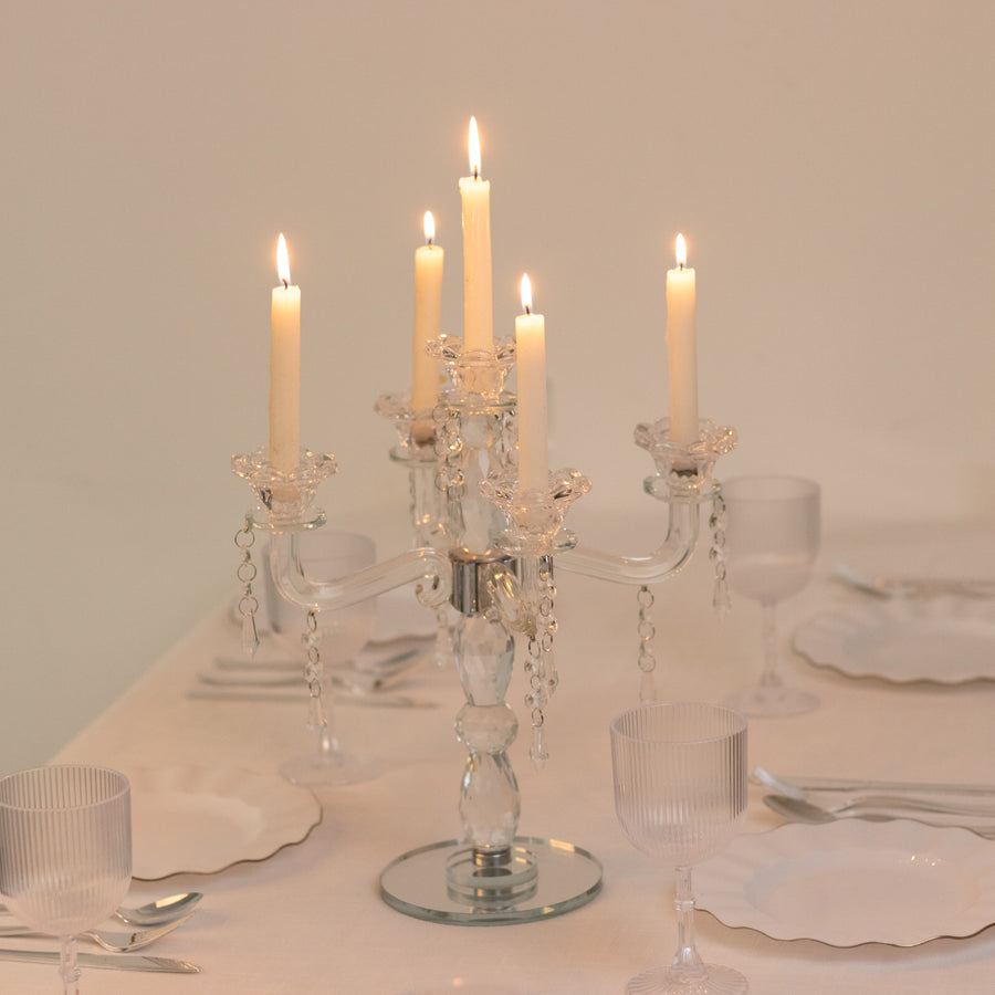 Elegant crystal candelabra with candles lit, enhancing dining ambiance.