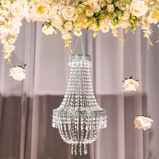 Elegant crystal chandelier hanging among floral decorations.