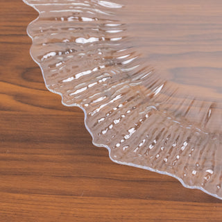 Clear decorative plate with a ruffled edge on a wooden surface.